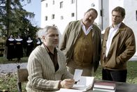 Die Rosenheim-Cops – Obwohl Dr. Schwenk (Hansa Czypionka, li.) in der Mordnacht im Kloster war, will er gegenüber den beiden Kommissaren Hofer (Joseph Hannesschläger, mi.) und Lind (Tom Mikulla) nichts von dem nächtlichen Lärm gehört haben.