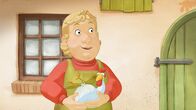 Lieselotte – Die Bäuerin hält ein Huhn im Arm.