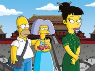 Die Simpsons – Selma (M.) entschließt sich, ein Kind zu adoptieren. Und da dies am einfachsten in China sein soll, fliegt sie mit der gesamten Familie Simpson nach Peking, wobei Homer (l.) sich als ihr Ehemann ausgeben muss ...