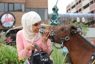 Tierische Freundschaften – Moni Ramouni smiles at and nuzzles noses with unlikely animal friend Cali, who is also Mona's miniature guide horse.