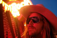 Look Me Over - Liberace – Der Schauspieler Lasse Sehsted Skafte als Cowboy, in dessen Sonnenbrille sich der Neonschriftzug mit Liberaces Signatur spiegelt