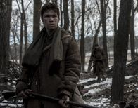 The Revenant - Der Rückkehrer – Jim Bridger (Will Poulter, l.) und John Fitzgerald (Tom Hardy, r.) schlagen sich zu zweit nach Fort Kiowa durch.