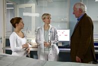 In aller Freundschaft – Gerd Steiger (Nikol Voigtländer, re.) macht sich Sorgen um seine Frau Rita, die unter einem postoperativen Delir leidet. Dr. Kathrin Globisch (Andrea Kathrin Loewig, mi.) und Schwester Julia (Sarah Tkotsch, li.) erklären Gerd die weitere Vorgehensweise. Ritas Gehirn muss stimuliert werden. Gerd soll persönliche Dinge von zu Hause mitbringen, mit denen Rita Erinnerungen verknüpft hat.