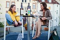 Labaule und Erben – Nach einer Idee von Harald Schmidt Esther (Inka Friedrich, re.) geht in die Offensive und besucht die Geliebte ihres Mannes, um mehr über Lenas (Emily Cox) Pläne für ihr ungeborenes Kind zu erfahren. Aber im Laufe des Gesprächs ergeben sich ganz andere, viel positivere Perspektiven …