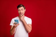 111 – Photo portrait of young man curious thoughtful looking blank space touching chin isolated vivid red color background