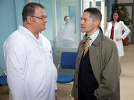 In aller Freundschaft – Hans-Peter Brenner (Michael Trischan, links) folgt mit einem mulmigen Gefühl Elena Eichhorns (Cheryl Shepard, hinten rechts) Rat: Er fragt Dr. Kaminski (Udo Schenk), ob dieser ihm ein paar Übungsstunden für Nahttechniken geben kann. Erwartungsgemäß lässt Kaminski Brenner stehen.