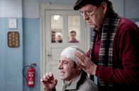 Alles Klara – MDR Fernsehen ALLES KLARA, FOLGE 16, "BioTot" Uhr. Paul Kleinert (Felix Eitner, l.) ist nach einer Kneipentour niedergeschlagen worden. Er lässt sich von Dr. Münster (Jörg Gudzuhn, r.) verarzten.