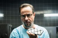 Tatort – Boerne (Jan Josef Liefers) setzt die Obduktion fort und telefoniert dabei mit Haller, die gerade im Kleingarten Pflanzen begutachtet.