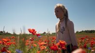 Cry Wolf – Holly (Flora Ofelia Hofmann Lindahl) streift durch ein Blumenfeld.