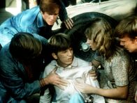 Die Waltons – Bei einer Reparatur ist ein Wagen auf Jim-Bob (David W. Harper, M.) gefallen. Er wird von seinem Vater John (Ralph Waite, l.) und seinen Geschwistern Ben (Eric Scott, 2.v.l.), Mary Ellen (Judy Norton-Taylor) und Jason (Jon Walmsley) geborgen.