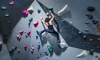 TM Wissen – Frau klettert auf Indoor-Kletterwand.