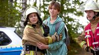 Feuerwehrfrauen – Persönlicher Einsatz: Anja (Nadja Becker, li.) hält Sohn Lasse (Elias Leon Philippi, Mitte) zurück. Ihr brennender Wohnwagen ist nicht mehr zu retten. Rechts: Ortswehrführer Rainer (Merlin Sandmeyer)