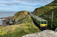 Mit dem Zug ... – Der DART lässt die letzte Klippe hinter sich liegen: Der Nahverkehrszug zwischen Greystones und Bray fährt auf eingleisiger Strecke. Parallel zur Bahn verläuft ein Spazierweg, der Cliff Walk.
