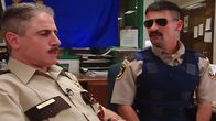 Reno 911! – L-R: Deputy James Garcia (Carlos Alazraqui), Deputy Travis Junior (Robert Ben Garant)
