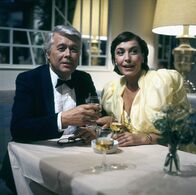 Ich heirate eine Familie – Angi (Thekla Carola Wied) und Werner (Peter Weck) beobachten als besorgtes Ehepaar auf einem Ball, wie Tanja sich auf dem Parkett bewegt.