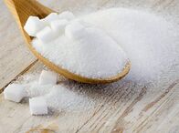 Zucker - Die süße Droge – Zucker auf Holztisch
