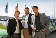 Die Rosenheim-Cops – Im Yachthafen stellen die Cops Stadler (Dieter Fischer, M.) und Hansen (Igor Jeftic, r.) Bürgermeister Schretzmayer (Jürgen Tonkel, l.) zur Rede.