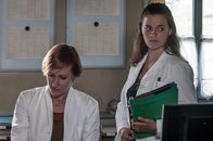 Der Bergdoktor – Irena Bornholm (Nicole Beutler, l.) reicht Lilli Gruber (Ronja Forcher, r.) einen Stapel Akten zur Bearbeitung.