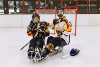 Checker Tobi – Beim Sledgehockey sitzen die Spieler in einem Schlitten mit Kufen darunter. Links: Checker Tobi.