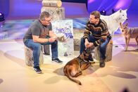 1, 2 oder 3 – Naturführer Stephan Kaasche (r.) erklärt Elton (l.), wie er Wölfen mit seinem Hund Amina im Wald auf die Spur kommt.