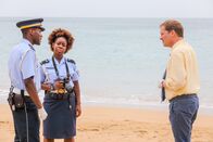 Death in Paradise – JP Hooper (Tobi Bakare) und Ruby Patterson (Shyko Amos) berichten DI Jack Mooney (Ardal O'Hanlon) von den neuesten Erkenntnissen.