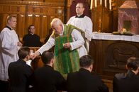 Father Brown – In der Upcott-Bruderschaft stürzt der Priesteranwärter Thomas Potts vom Glockenturm. Im Bild Father Palfreyman (Dudley Sutton, M.) während der Kommunion. (Andere Darsteller im Bild unbekannt)