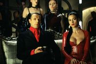 The Matrix Revolutions – Neo befindet sich in einem Ort zwischen der Matrix und der realen Welt - und nur ein Untergebener des Merovingian (Lambert Wilson, l.) kann ihn wieder zurückholen. Also machen sich Morpheus , Trinity und Seraph auf den Weg in Merovingians Hölle, wo sie auch auf Persephone (Monica Bellucci, r.) treffen ...