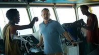 Captain Phillips – Mit finsteren Blicken und geübter Härte stürmen die somalischen Piraten Muse (Barkhad Abdi, l.) und Najee (Faysal Ahmed, r.) das Steuerhaus eines riesigen Frachters und bedrohen den Kapitän Richard Phillips (Tom Hanks, M.).