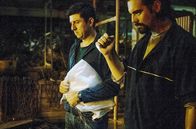 Eden – Alexandros (Theo Alexander, re.) und Yiannis (Michalis Ikonomou, li.) kehren zum Unfallort zurück, am Boden liegt die Leiche des Flüchtlings Daniel.