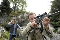 Der Bergdoktor – Martin (Hans Sigl, l.) und Dirk Amann (Felix Eitner, r.) suchen nach dem Adler. Dirk erspäht ihn, nimmt das Gewehr, stützt es auf einen Felsvorsprung und zielt - der Betäubungspfeil schießt aus dem Lauf.
