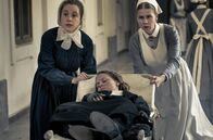 Charité – Ida Lenze (Alicia von Rittberg, M.) wird mit Verdacht auf Blinddarmentzündung in die Charité eingeliefert. Schwester Therese (Klara Deutschmann, l.) und Wärterin Edith (Tanja Schleiff, r.) verlieren keine Zeit.