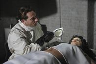 American Horror Story – 1947: Zahnarzt Dr. Curran (Joshua Malina, l.) erklärt sich bereit, die hübsche Schauspielerin Elizabeth Short (Mena Suvari, r.) zu behandeln, was fatale Folgen für die Patientin haben wird ...
