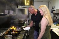 Restaurant Impossible – Host Robert Irvine shows Julie a few new tricks in the kitchen, as seen on Food Network's Restaurant: Impossible, Season 12.