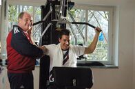 Arme Millionäre – Christoph Münzber (David Winter, re.) kann sich ein privates Fitnesstraining mit dem Manager des FC Bayern Uli Hoeneß leisten.