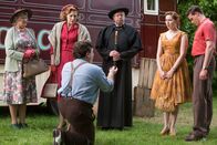 Father Brown – Smythe (Sevan Stephan, vorne) geht auf die Knie und macht Laura (Justine Cain, 2. v. r.) einen Antrag. Doch die ist bereits verlobt mit Nicholas (Joe Layton, r.). Mrs McCarthy (Sorcha Cusack, l.), Lady Felicia (Nancy Carroll, 2. v. l.) und Father Brown (Mark Williams, m.) sind unfreiwillig Zeugen.