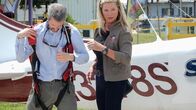 Airplane Repo - Die Inkasso-Piloten – Valerie Kennedy helps the debtor into his parachute.