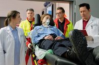In aller Freundschaft – Vom Notarzt (Markus Neumann, 2.v.re.) wird eine angeschossenen Polizistin (Melanie Huszka, mi.) in die Sachsenklinik eingeliefert. Dr. Maria Weber (Annett Renneberg, li.) und Dr. Philipp Brentano (Thomas Koch, re.) trauen ihren Ohren nicht, als sie hören, dass dies bei einem bewaffneten Banküberfall passiert ist. hi.: Rettungssanitäter (Komparse)