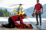 Der Bergdoktor – Im Hangar der Bergretter ist Pilotin Maike (Amelie Kiefer) zusammengebrochen. Hans (Heiko Ruprecht, l.) und Tom (Matthias Ransberger, r.) kümmern sich um sie.