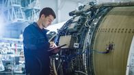 Aircraft Doctors – Aircraft Maintenance Mechanic Inspecting and Working on Airplane Jet Engine in Hangar