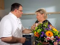 In aller Freundschaft – Pfleger Hans-Peter Brenner (Michael Trischan) bringt Sabine Schneider (Daniela Hoffmann) Blumen. Sabine Schneider ist äußerst angetan von Hans-Peter, dem das allerdings ziemlich unangenehm ist und er nicht weiß, wie er aus dieser Situation herauskommt. Doch plötzlich setzt bei Sabine Schneider wieder starkes Herzrasen ein - und das hat nichts mit Hans-Peter zu tun.