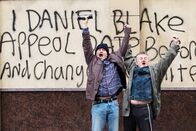 Ich, Daniel Blake – Nach einem weiteren frustrierenden Vorsprechen beim Amt greift Daniel Blake (Dave Johns, links) schließlich zu drastischen Mitteln um sich Gehör zu verschaffen. Er sprüht seine Forderung auf Widerrufung auf die Außenwand des Amtes. Für seine Courage wird er von einem vorbeigehenden Passanten als Held gefeiert.