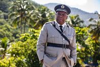 Death in Paradise – Commissioner Selwyn Patterson (Don Warrington) nimmt Marlons Nachfolger, Officer Dwayne, in Empfang, doch der Neuzugang bringt auch unerwartete Herausforderungen ins Team.