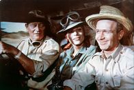 Hatari – Sean Mercer (John Wayne) und Pockets (Red Buttons, r.) sind hartgesottene Großwildjäger einer Fangstation in Tansania. Eines Tages stößt die junge Fotografin Anna Maria "Dallas" D'Allessandro (Elsa Martinelli, M.) zu ihrem Team ...