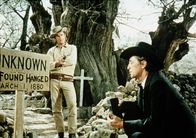 Todfeinde – Nick Evers (Roddy McDowall, l.) bedroht den trauernden Prediger Rudd (Robert Mitchum, r.) mit einer Waffe - doch der ist gefährlicher, als er aussieht ...