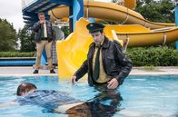 Hubert und Staller – Hubert (Christian Tramitz, l.) und Staller (Helmfried von Lüttichau, r.), machen im Schwimmbad einen grausigen Fund. Auf der Wasserrutsche sitzt Bademeister Frank Brauß, erstochen! Bei dem Versuch den Toten genauer zu betrachten, rutscht Staller samt der Leiche ins Wasser.