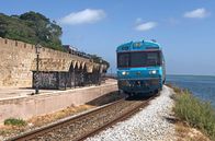 Mit dem Zug ... – Einfahrt in Faro: Der Zug fährt zwischen der Lagune und der Stadtmauer der Altstadt entlang.