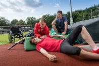 Notruf Hafenkante – Mattes (Matthias Schloo, r.) ist zufällig vor Ort, als dem Stabhochspringer Josh Baier (Daniel Fünffrock, liegend) beim Training der Stab bricht. Während Joshs Trainer Alex Wissmann (Sebastian Achilles, l.) nach seinem Schützling sieht, ruft Mattes den Notarztwagen.