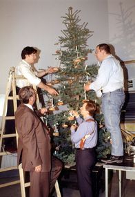 Kommissar Rex – Kommissar Moser (Tobias Moretti, hinten l.), Dr. Graf (Gerhard Zemann, vorne l.), Peter Höllerer (Wolf Bachofner, hinten r.) und Christian Böck (Heinz Weixelbraun, vorne r.) schmücken den Weihnachtsbaum in ihrer Dienststube. Mit Würstchen statt Baumschmuck ...