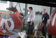 Mayday - Alarm im Cockpit – ONTARIO - RE-ENACTMENT - NTSC Investigator (played by Redd Ochao) looks over parts of the plane crash in the hanger while a BEA agent (played by a background performer) stands by.