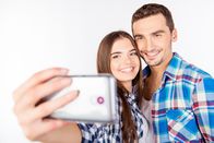 Big Stories – Closeup photo of a cheerful pretty couple in love making selfie